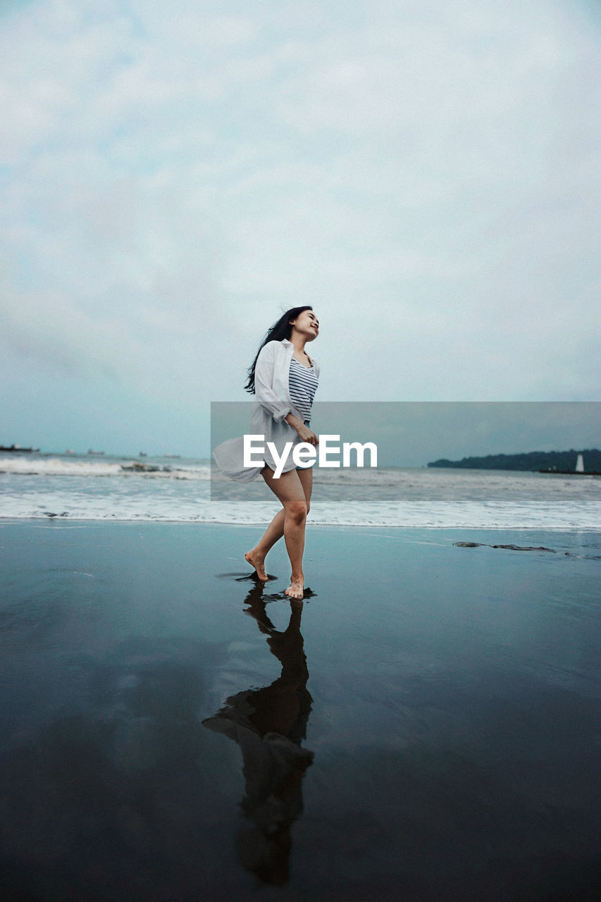 Full length of woman standing at beach