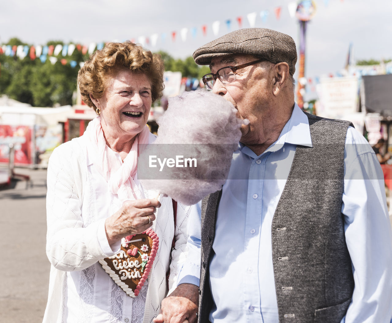 Senior couple on fair enjoying cotton candy