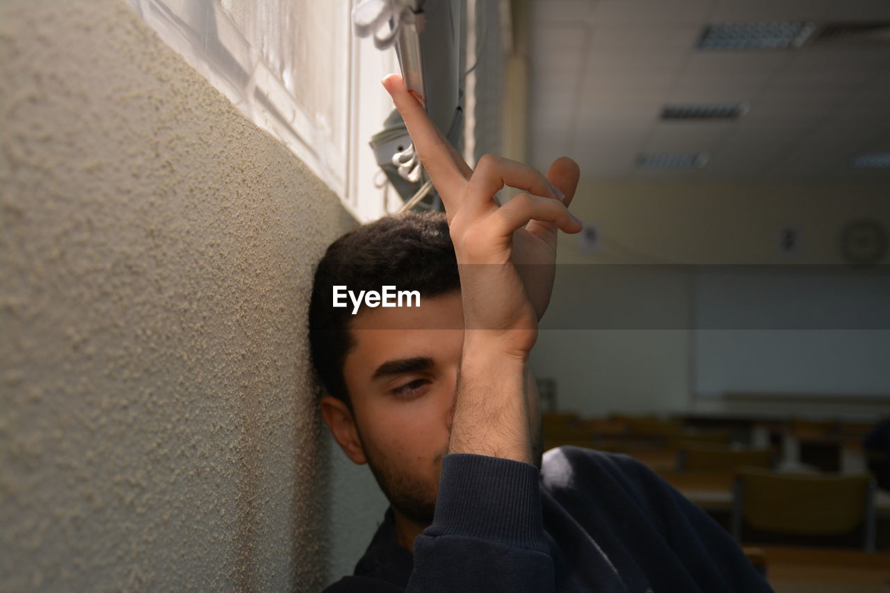 CLOSE-UP OF YOUNG MAN IN A ROOM