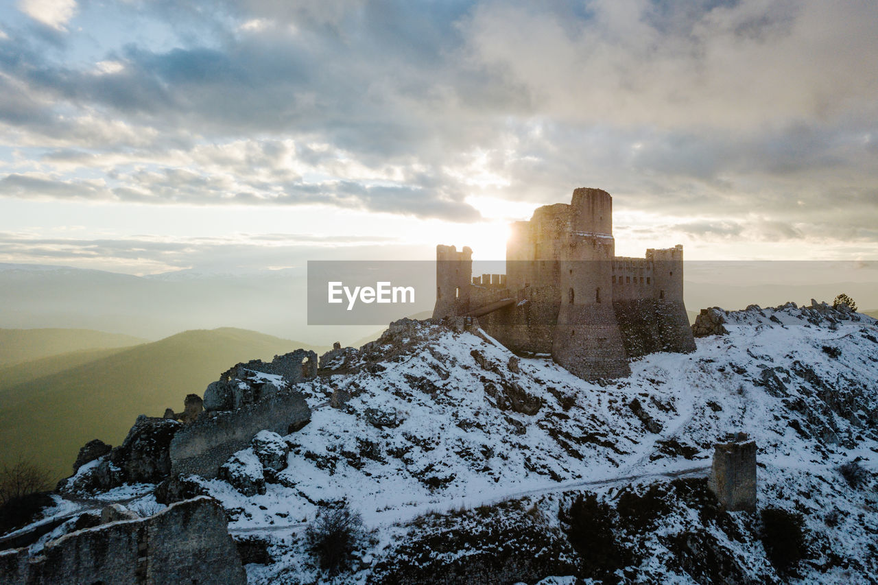 BUILDINGS ON MOUNTAIN AGAINST SKY DURING WINTER