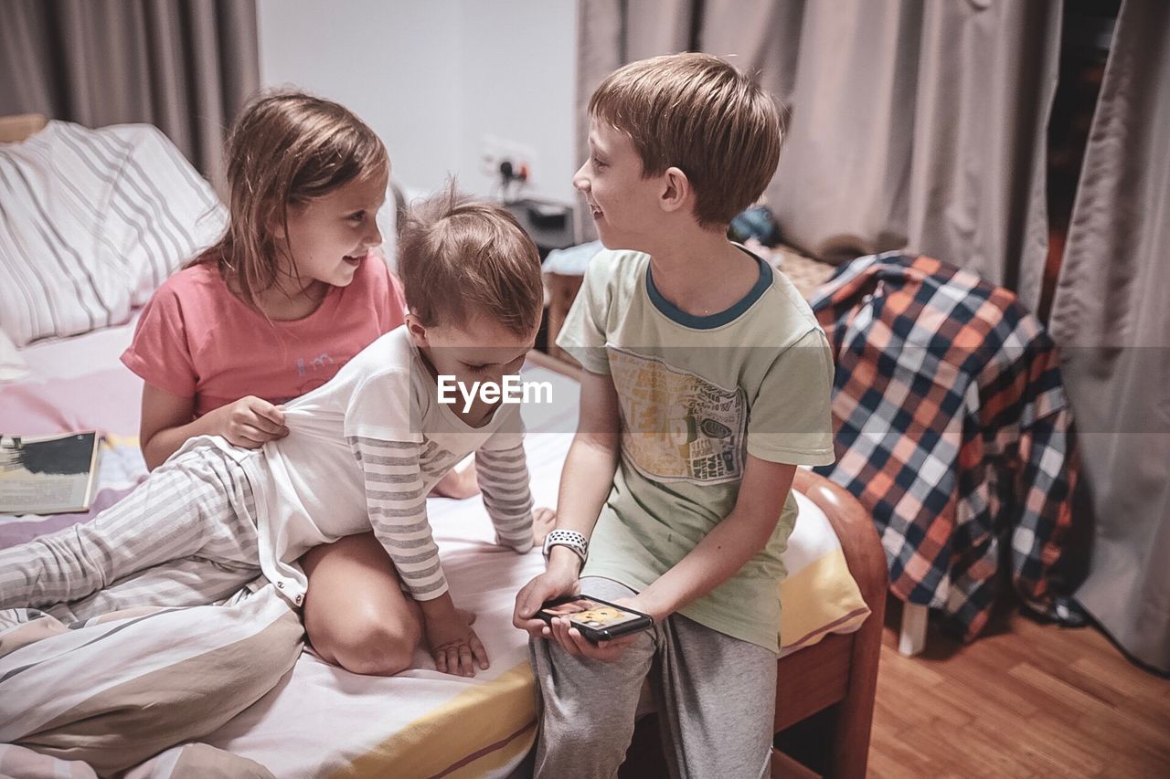 FATHER AND SON SITTING ON BED