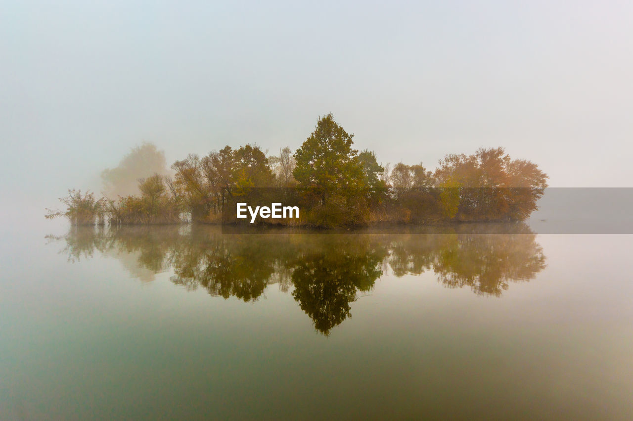 Reflection of trees in lake against sky