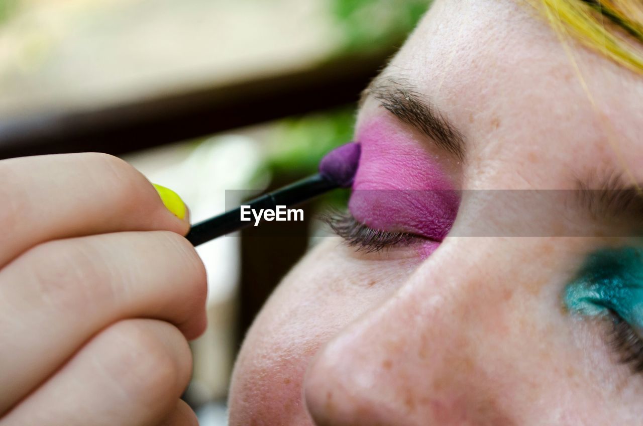 Close-up of woman applying eyeshadow