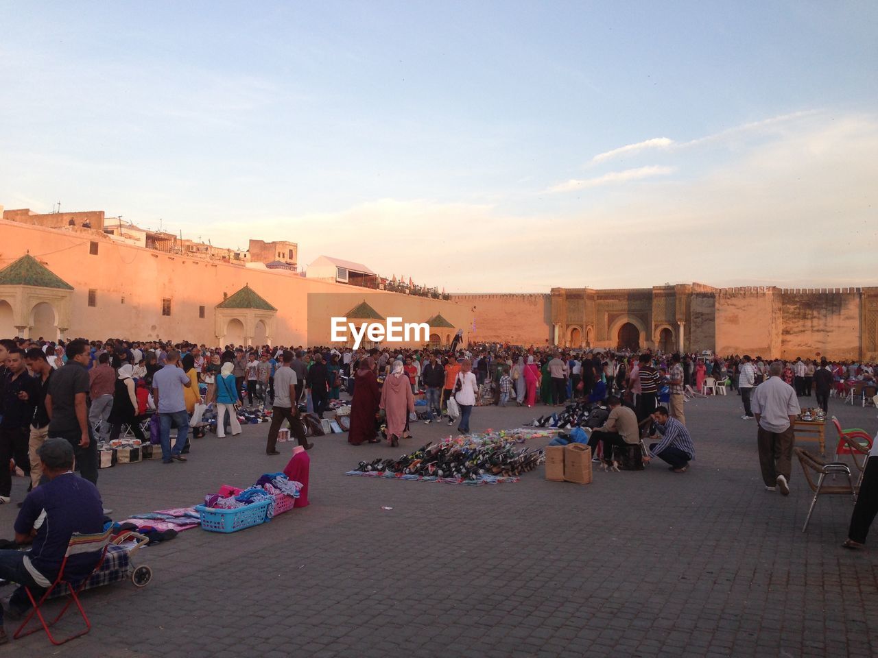 People at market by bab mansour against sky