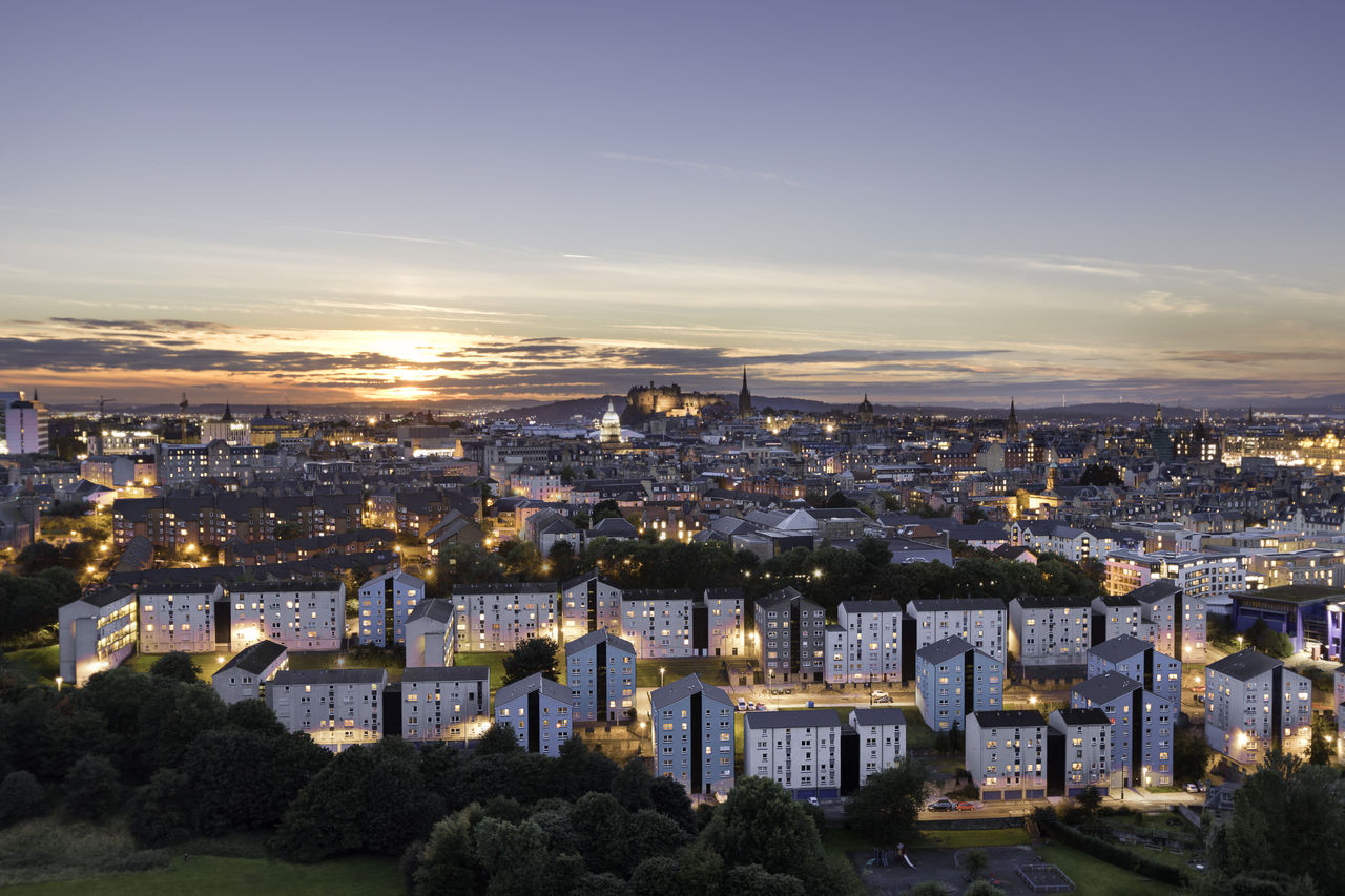 HIGH ANGLE VIEW OF ILLUMINATED BUILDINGS IN CITY