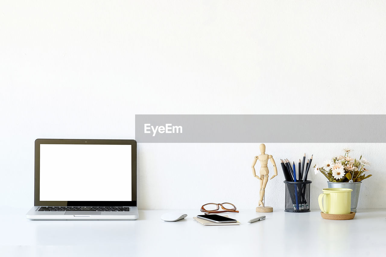 Laptop on table against white background