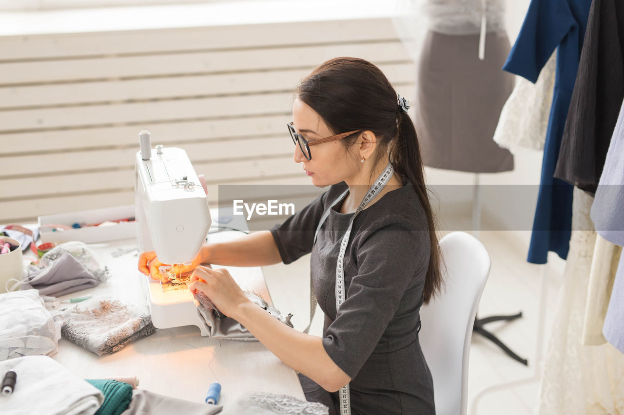 Side view of fashion designer working at studio