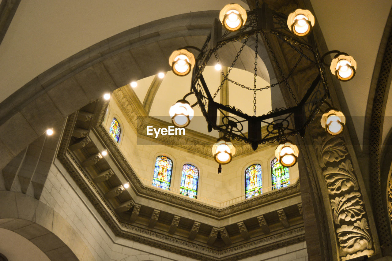 Low angle view of illuminated chandelier hanging in church