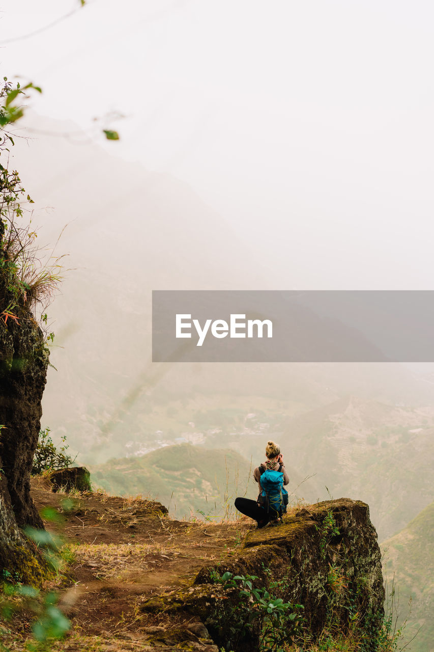 Man sitting on rock in mountains