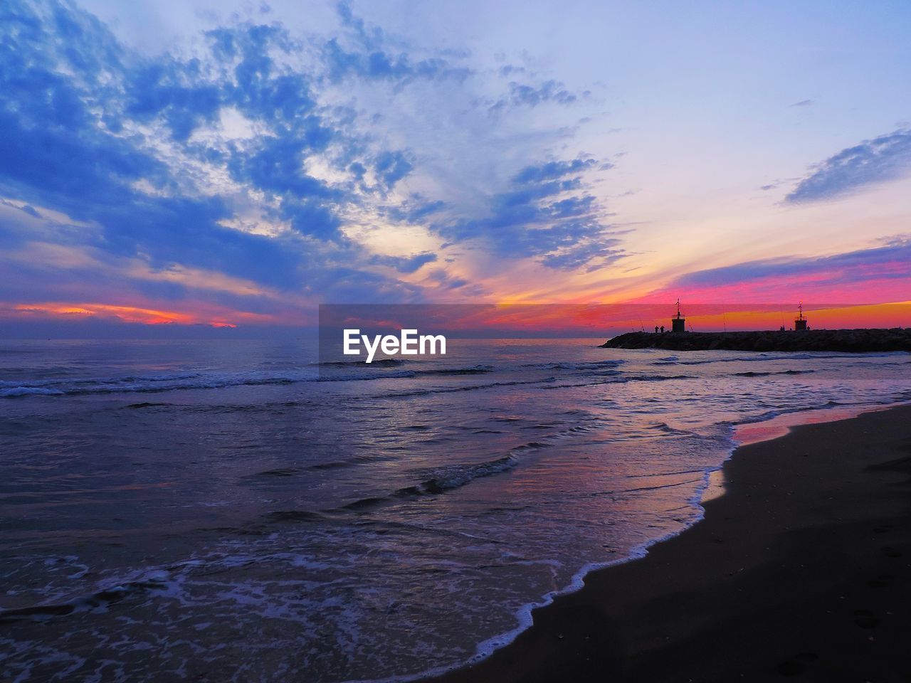 Scenic view of beach against sky during sunset