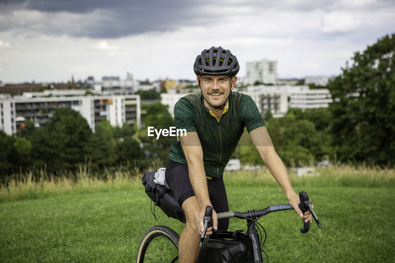 Portrait of man riding bicycle on grass