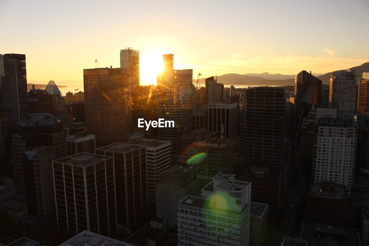 Buildings in city during sunset