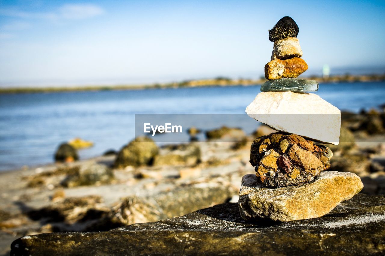 CLOSE-UP OF STONE STACK ON ROCK AT BEACH