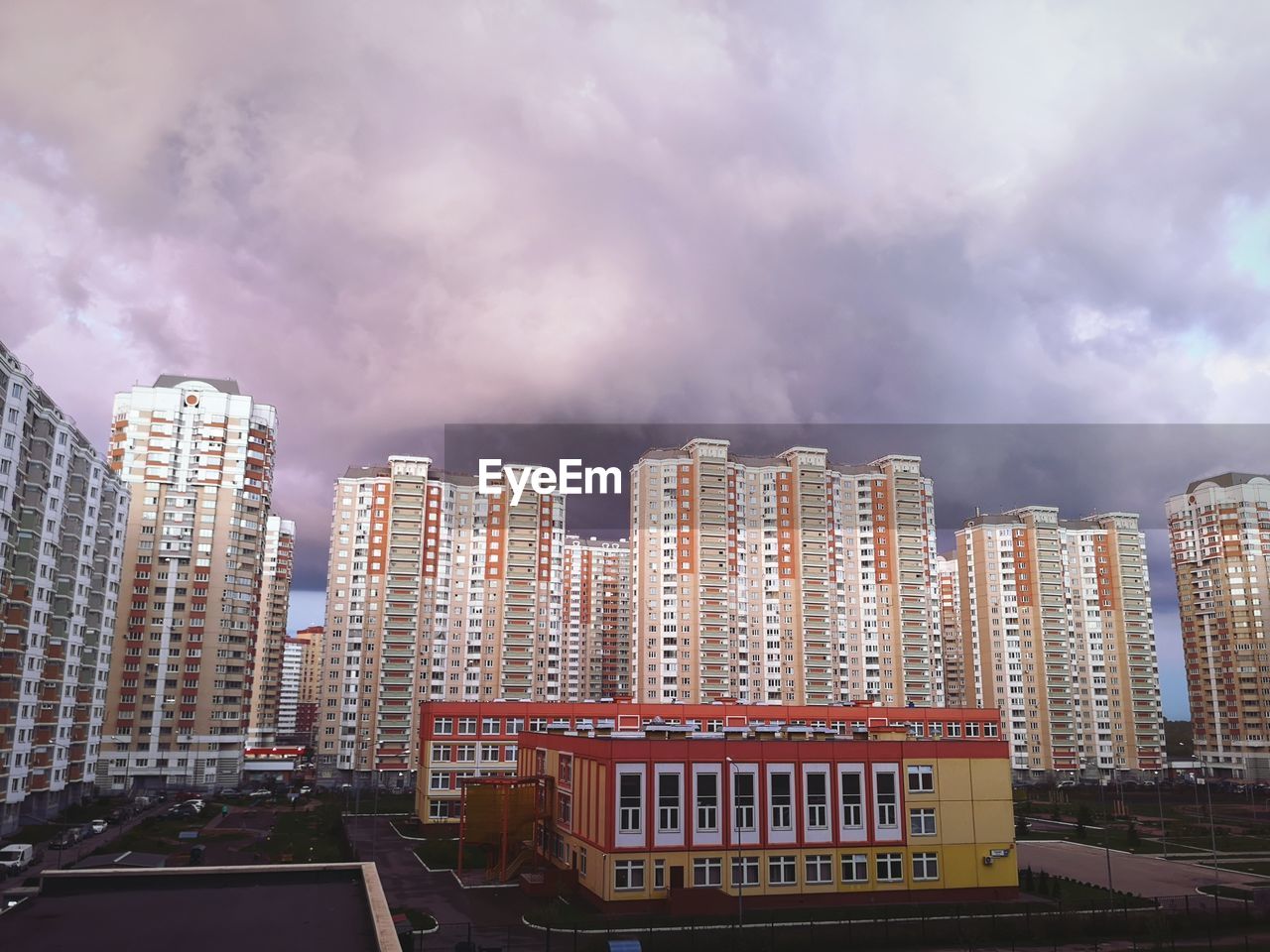 Modern buildings in city against storm clouds