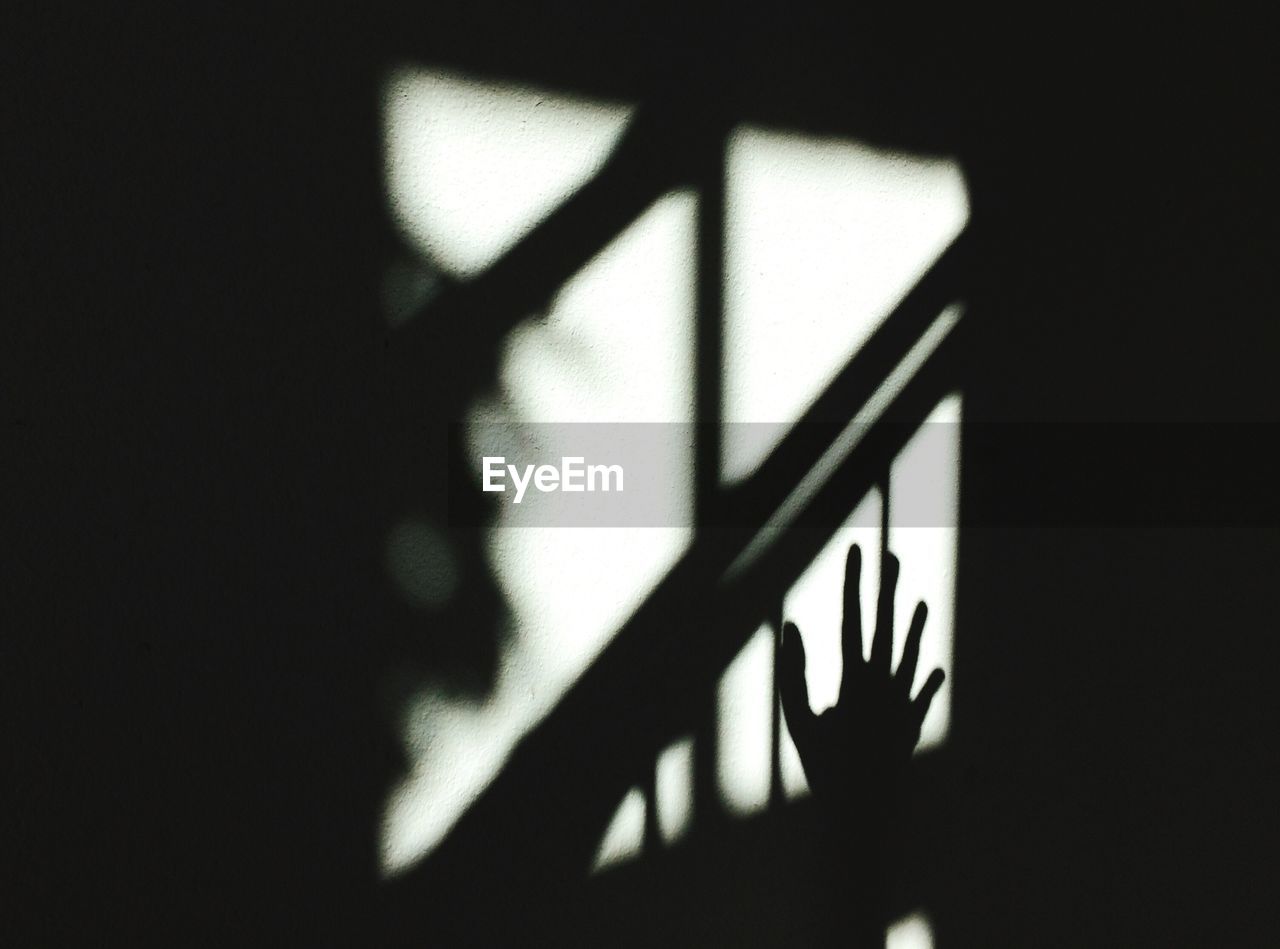 Shadow of cropped hand on wall