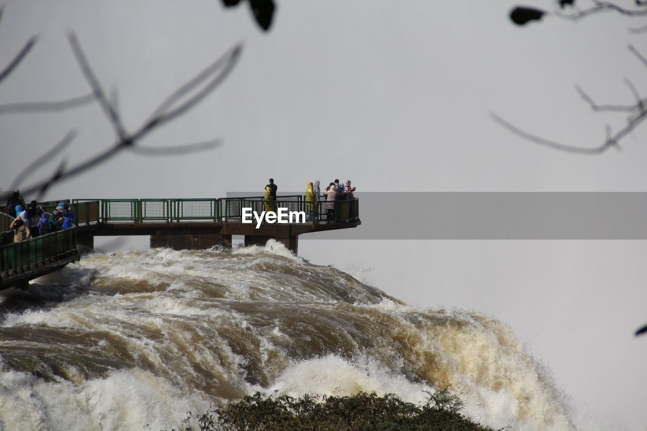 Tourists at observation point watching iguazu falls