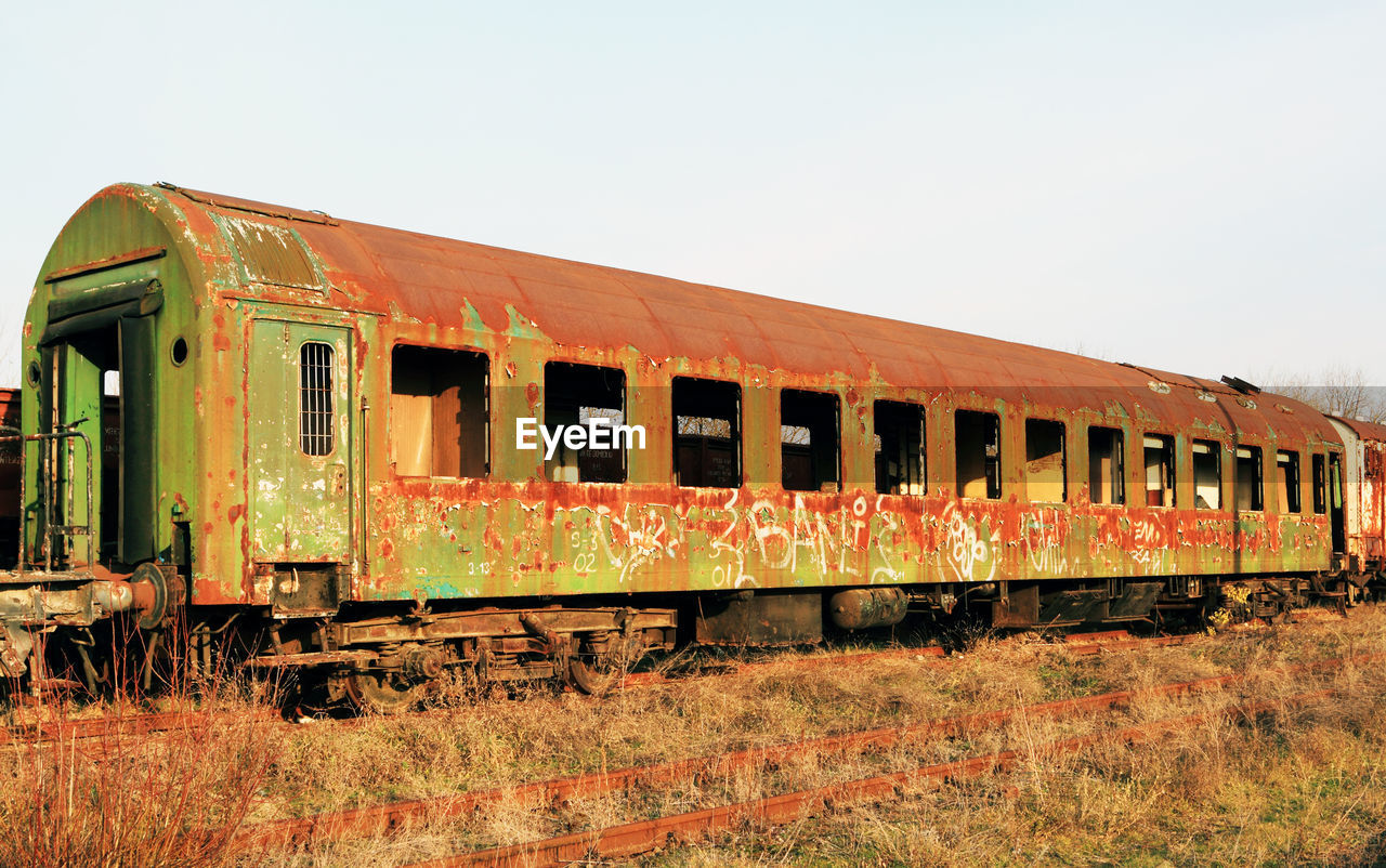 TRAIN ON RAILROAD TRACK AGAINST CLEAR SKY