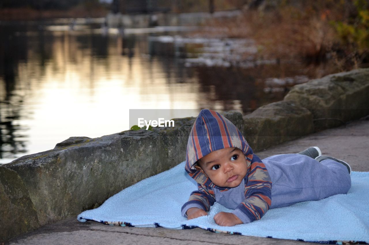 PORTRAIT OF BOY LYING ON WATER