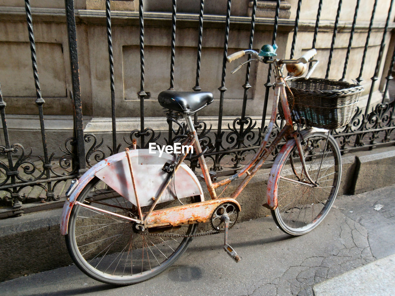 BICYCLE PARKED ON METAL FENCE IN CITY