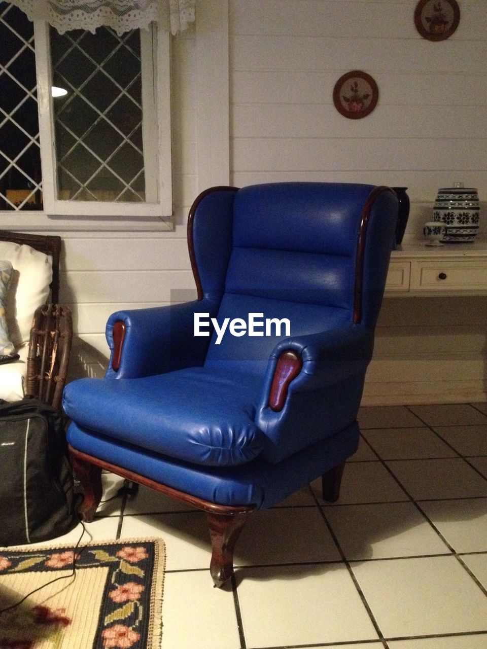 EMPTY CHAIR AGAINST BLUE WALL