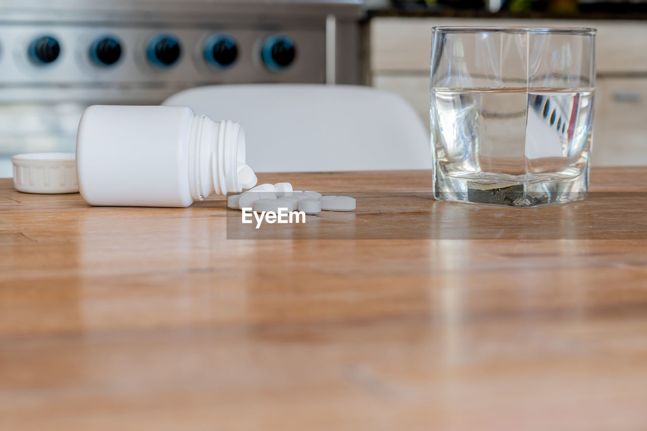 table, drinking glass, household equipment, glass, food and drink, indoors, drink, water, wood, no people, refreshment, drinking water, selective focus, domestic room, food, still life, day, white, cold drink, copy space, furniture, home interior