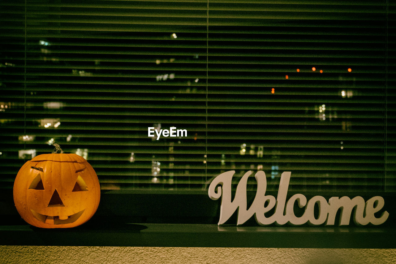 Welcome sign and halloween pumpkin on window sill