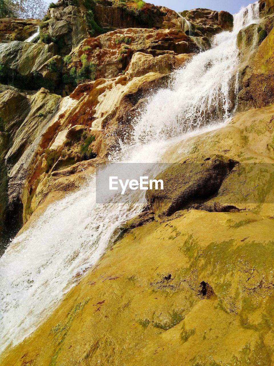 SCENIC VIEW OF WATER FLOWING THROUGH WATERFALL