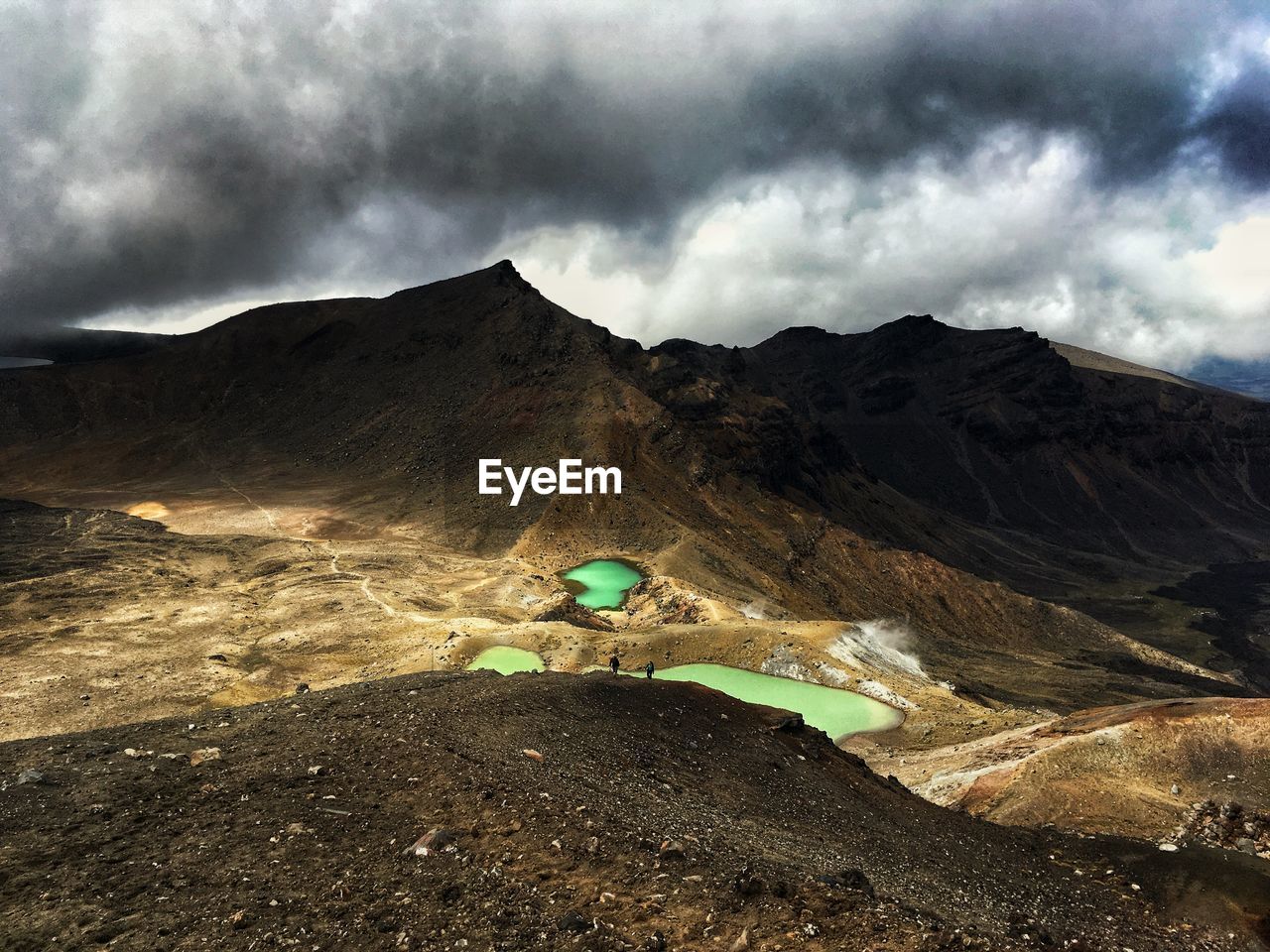 Scenic view of volcanic mountain against cloudy sky