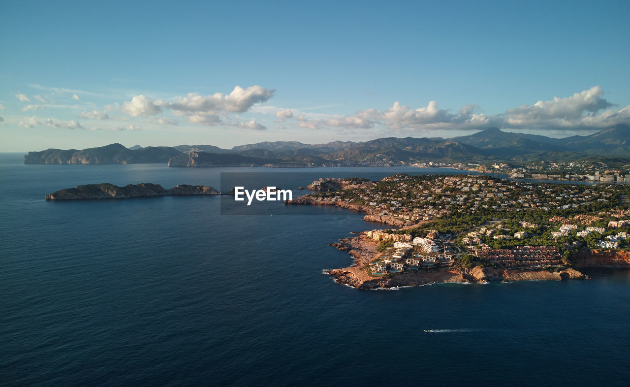 SCENIC VIEW OF SEA AND MOUNTAINS AGAINST BLUE SKY