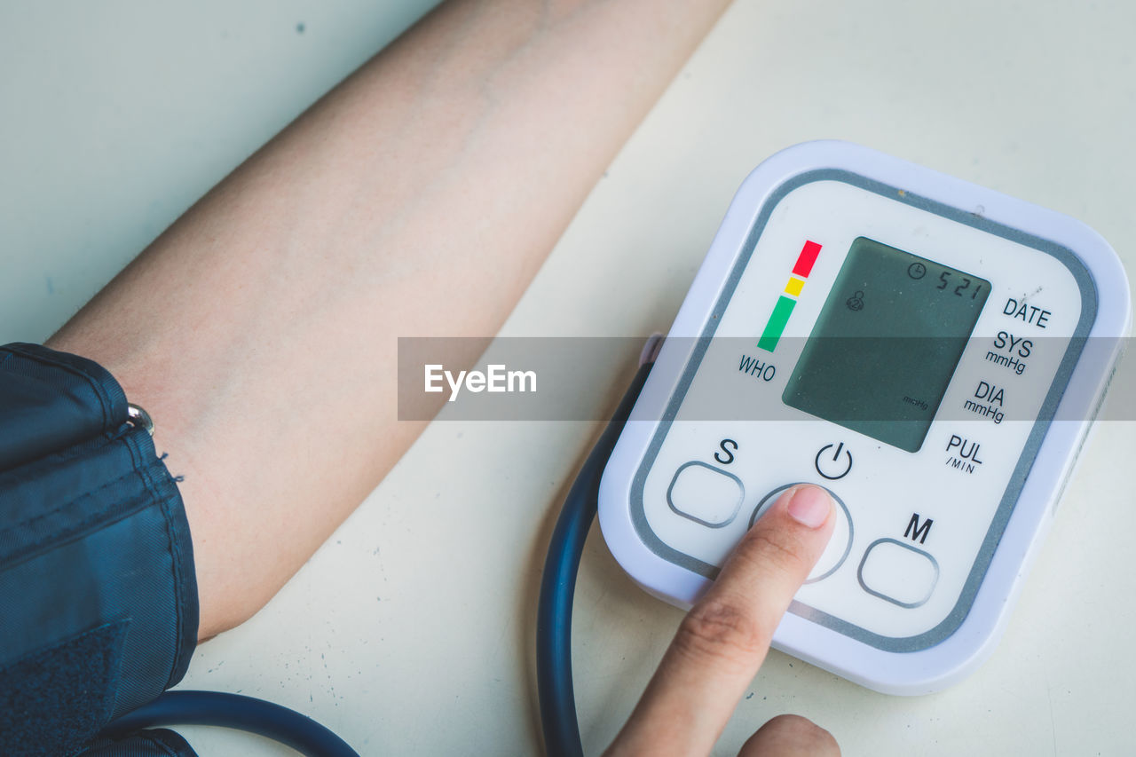 Cropped image of woman checking blood pressure on table