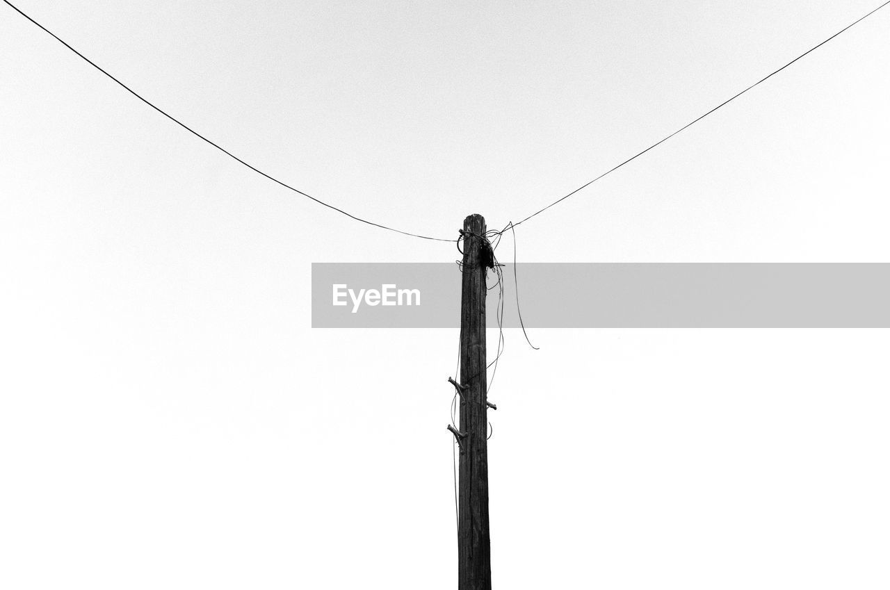 Low angle view of telephone pole against clear sky