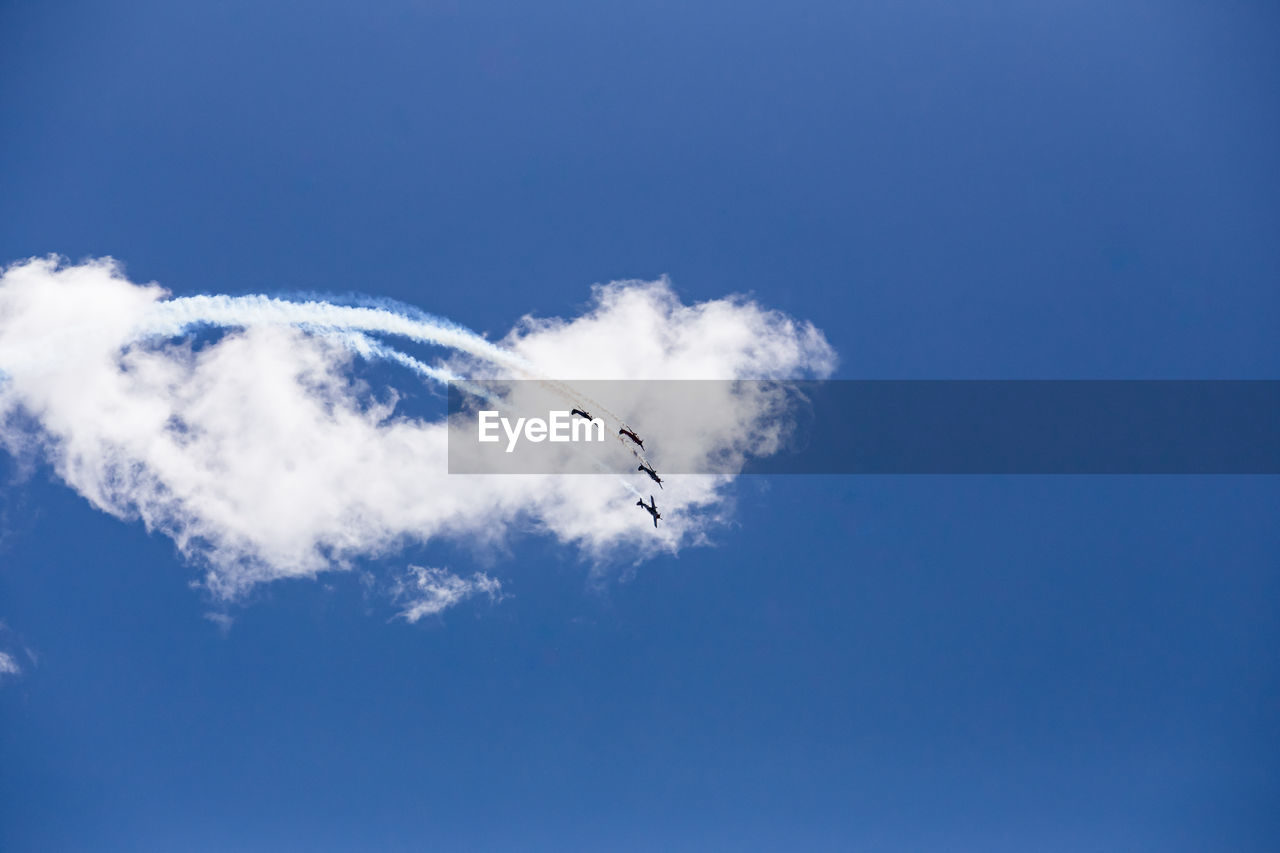 Low angle view of airplane flying against blue sky airshow