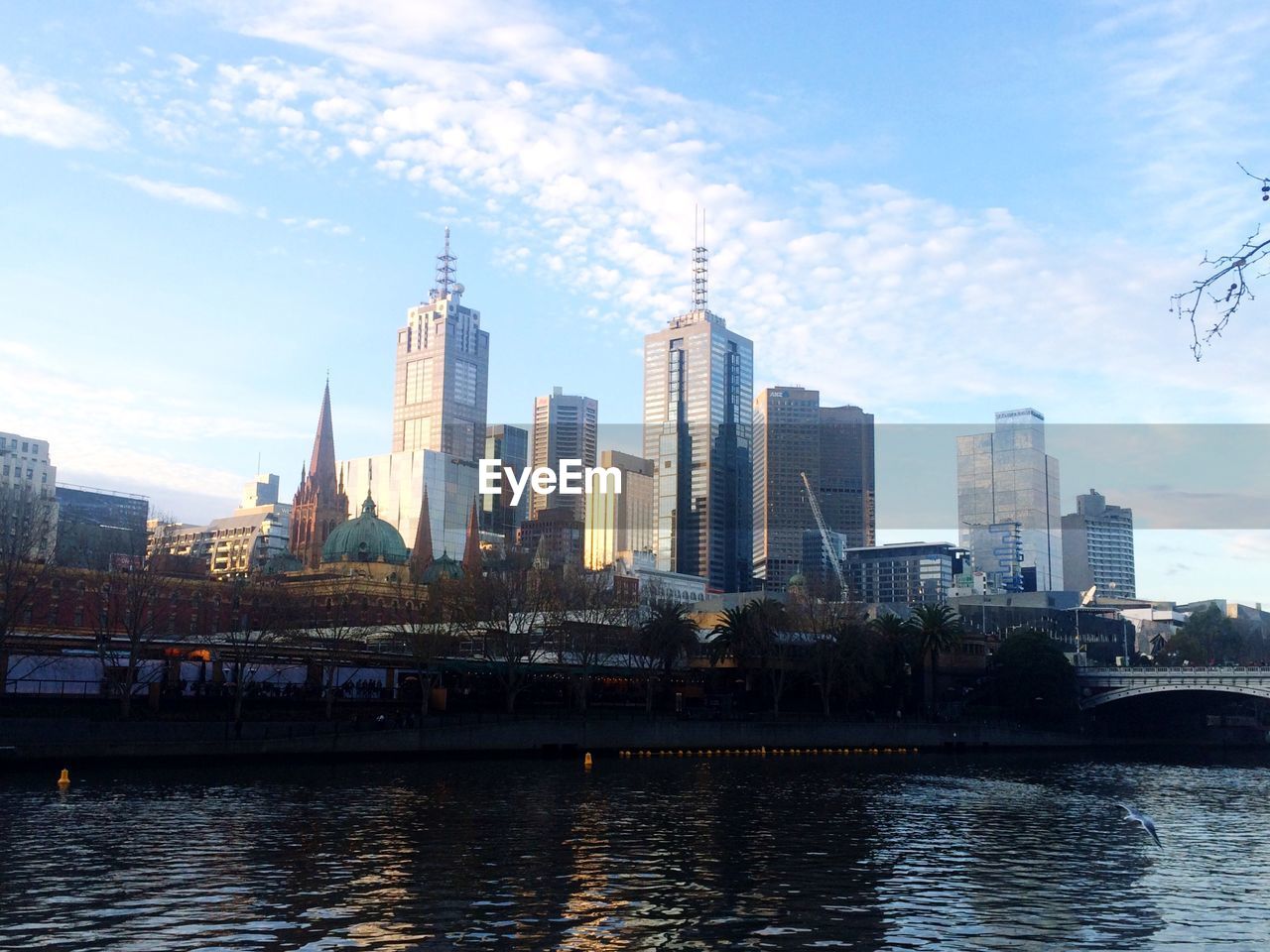 Yarra river by buildings against sky