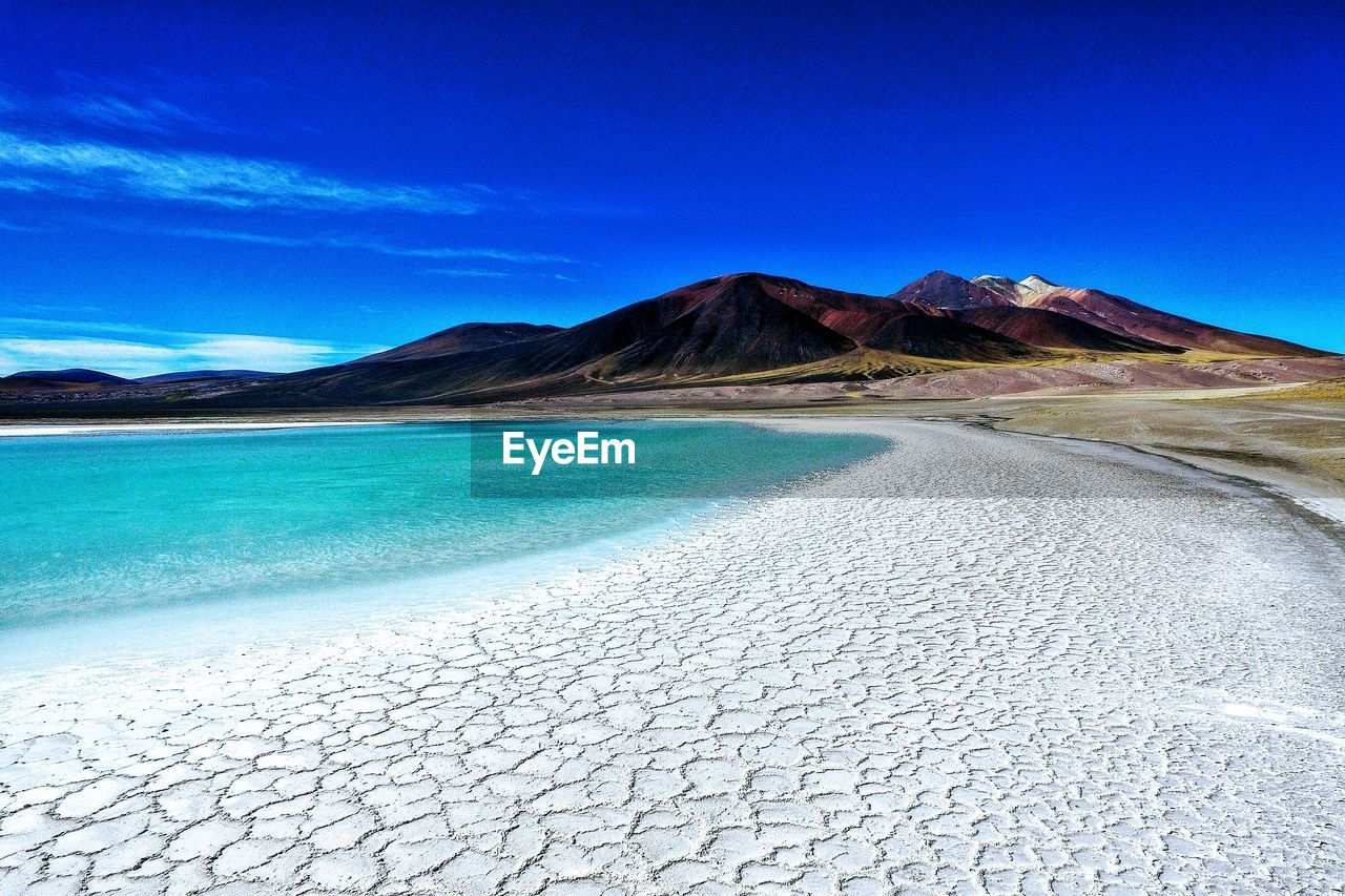 Scenic view of desert against clear blue sky