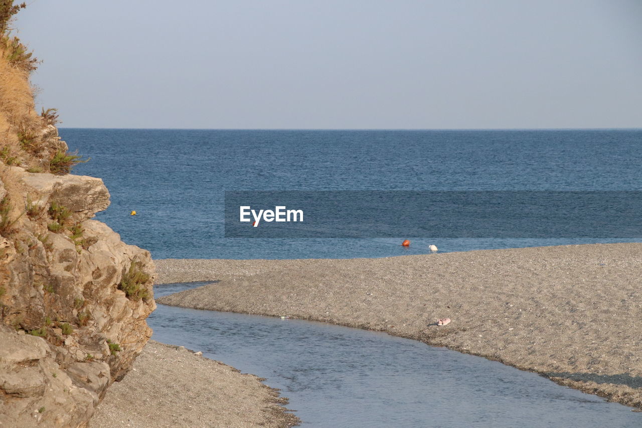 water, sea, shore, beach, sky, land, body of water, horizon over water, scenics - nature, nature, horizon, coast, beauty in nature, sand, ocean, tranquility, tranquil scene, bay, day, clear sky, cliff, vacation, terrain, rock, outdoors, blue, no people, travel, travel destinations, plant, holiday, idyllic, non-urban scene