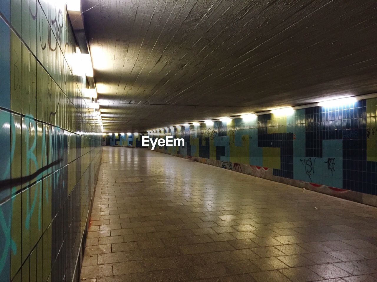 Interior of illuminated empty underground walkway