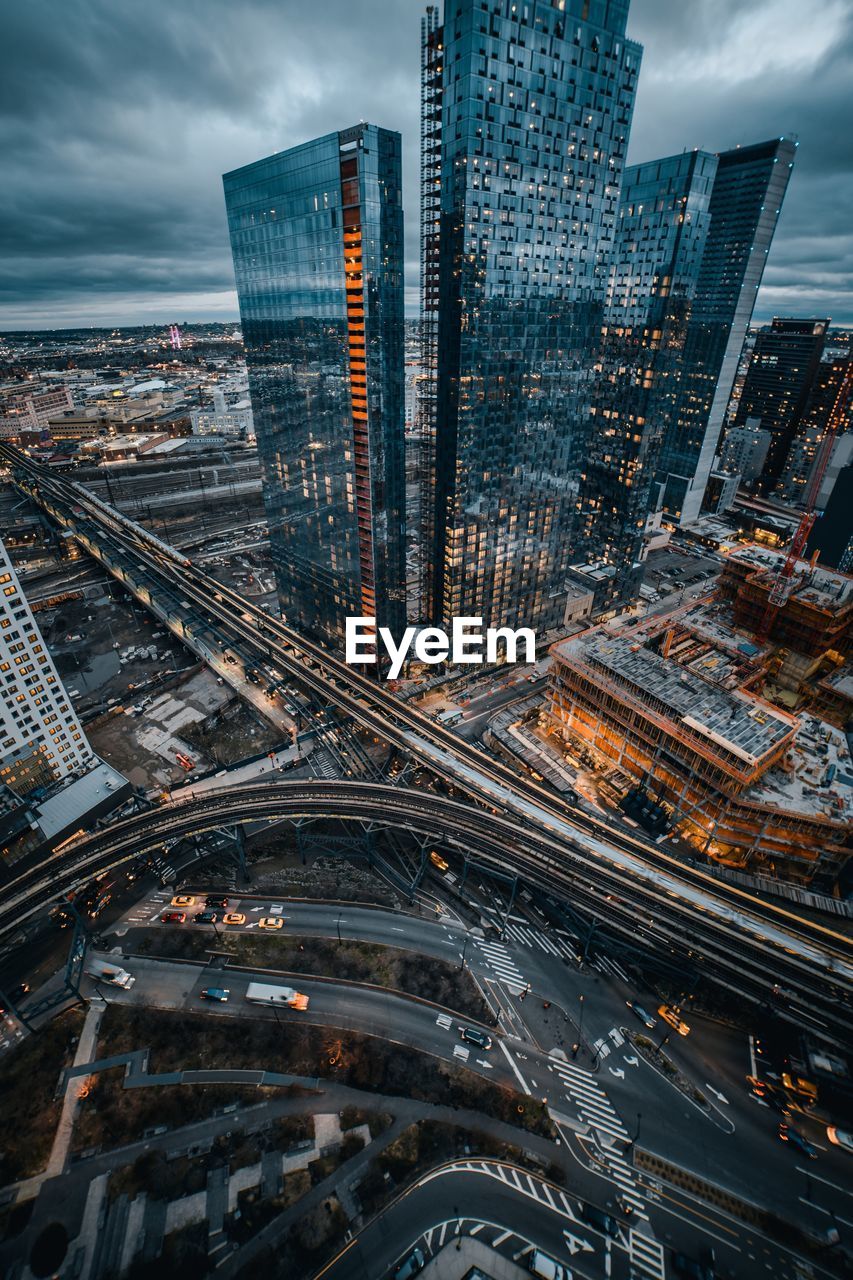 High angle view of city buildings against cloudy sky