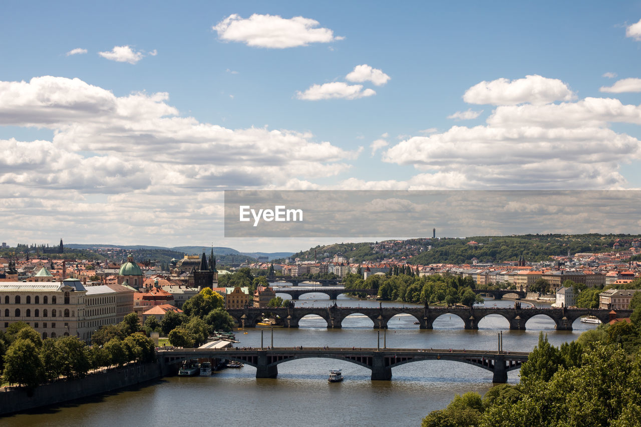 Bridge over river in city against sky