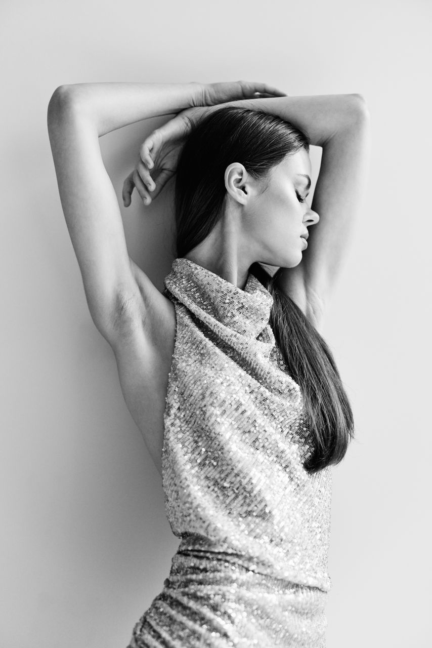 portrait of young woman standing against white background