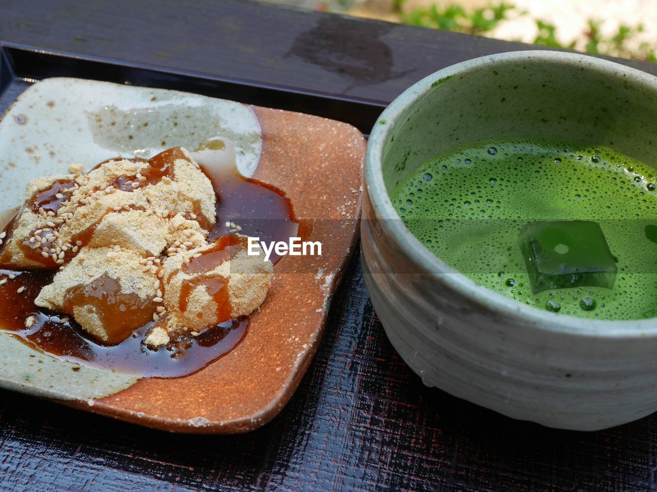 Close-up of rice cake served in plate with matcha tea on table