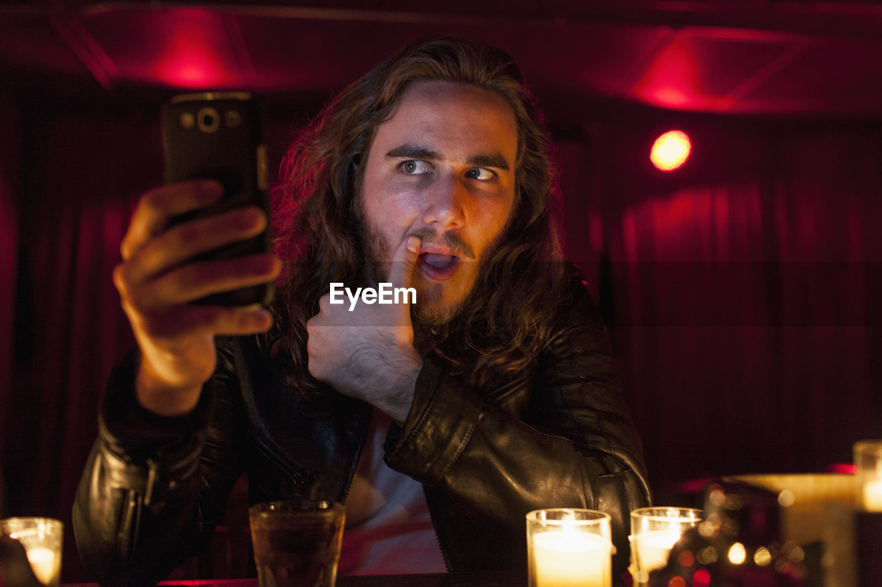 Young man checking his cell phone while at a nightclub