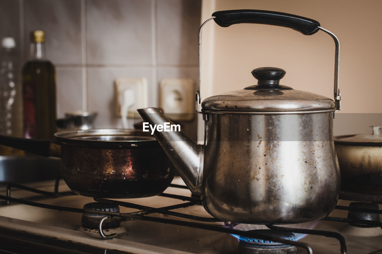 Close-up of kettle heating on burner in kitchen at home