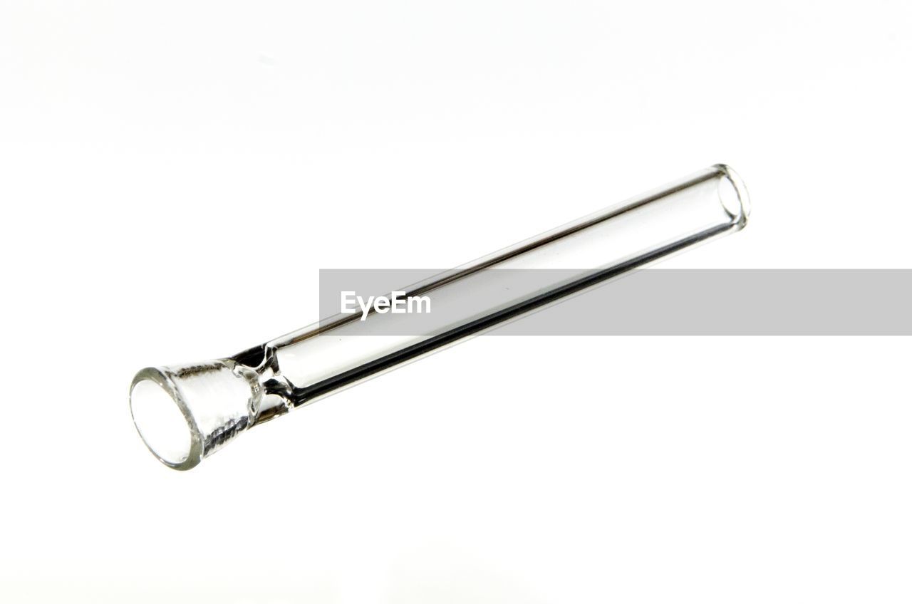 Close-up of glass pipe against white background