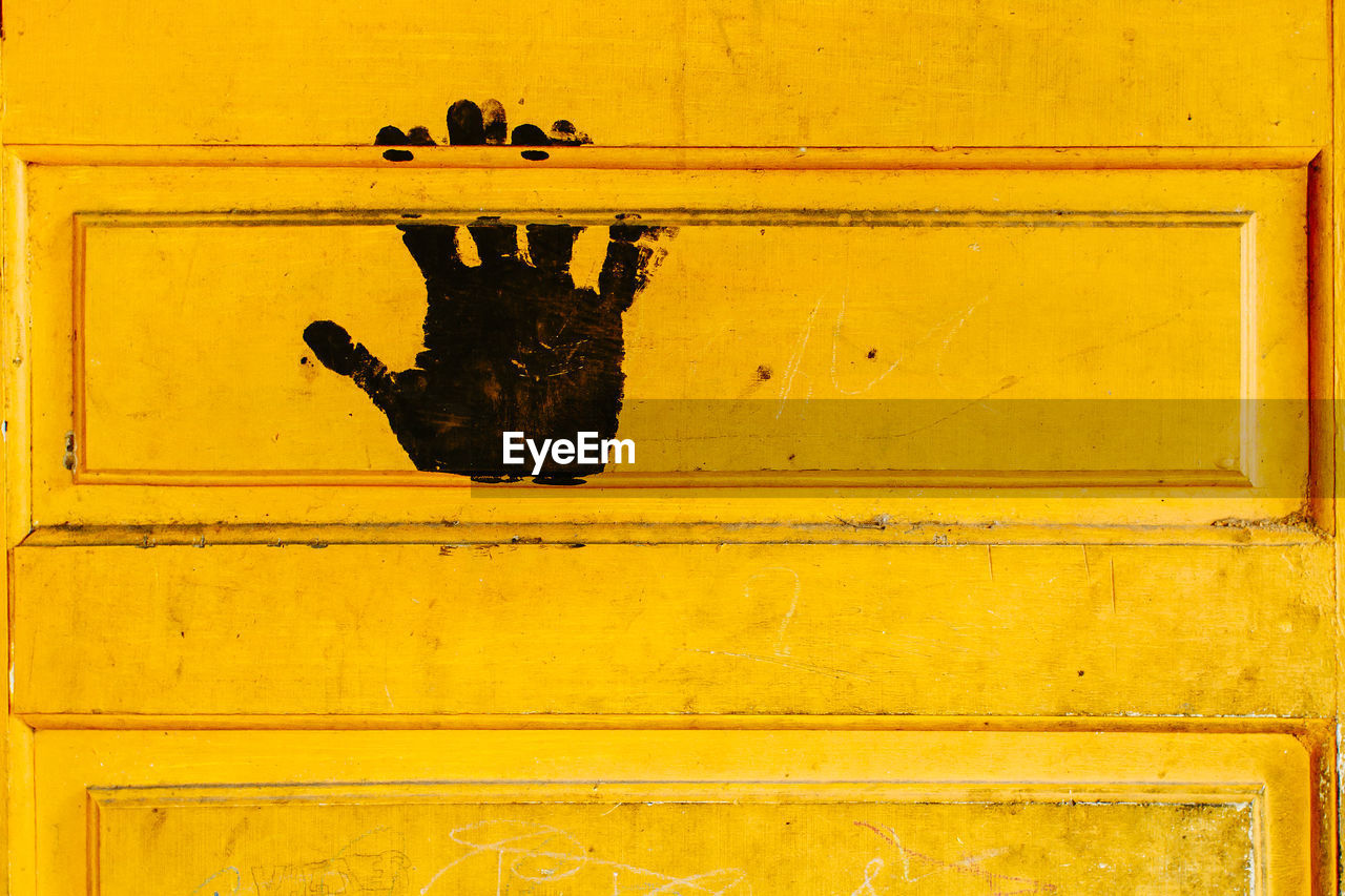 Close-up of black print on yellow door 