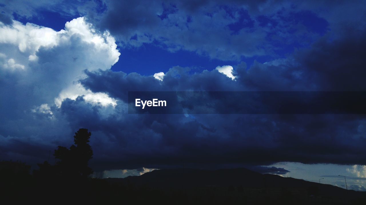 SILHOUETTE OF MOUNTAIN AGAINST CLOUDY SKY