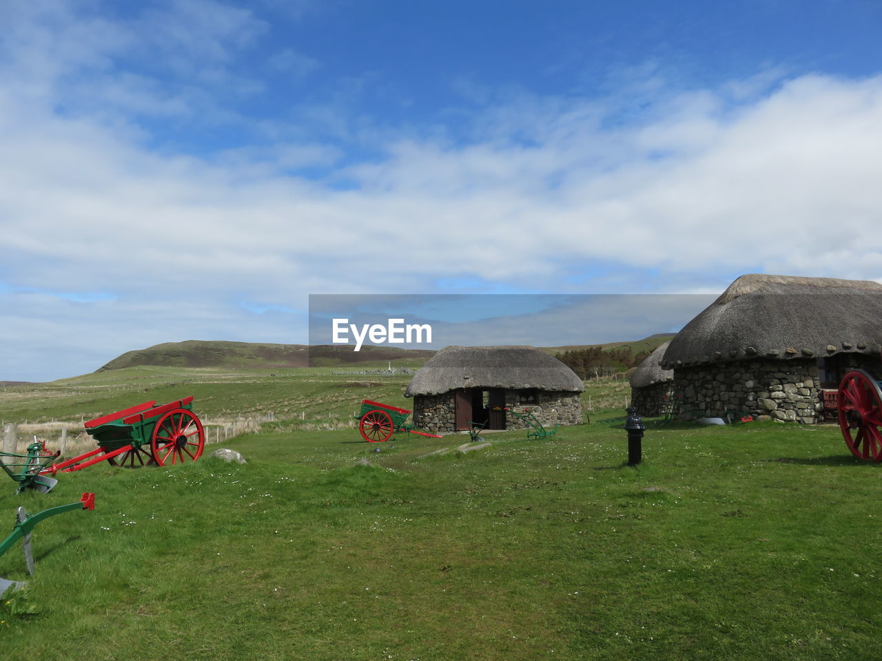 Scenic view of grassy field against cloudy sky