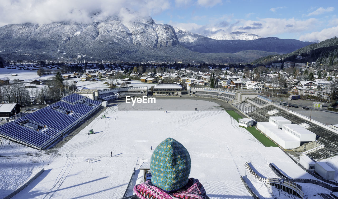 High angle view of woman standing against snowcapped mountains in city