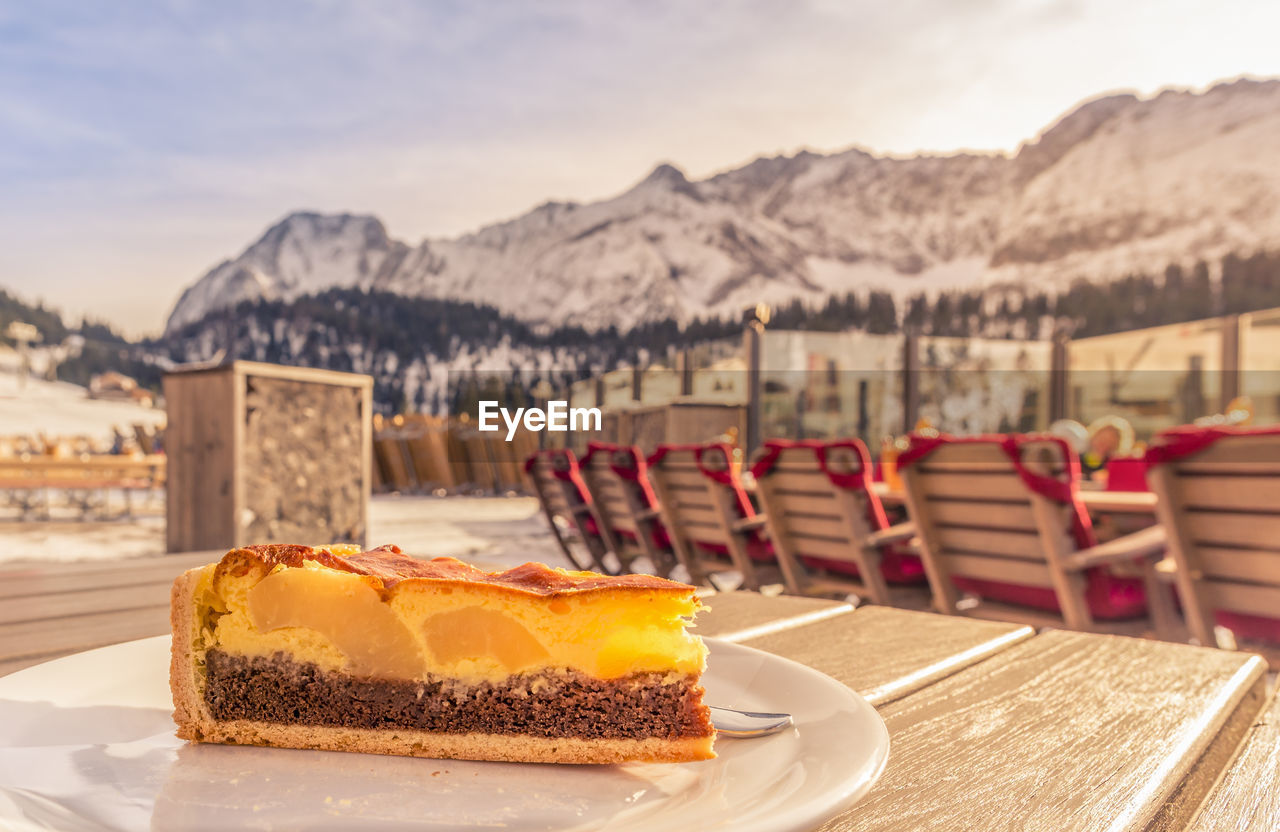 Close-up of cake on table against mountain