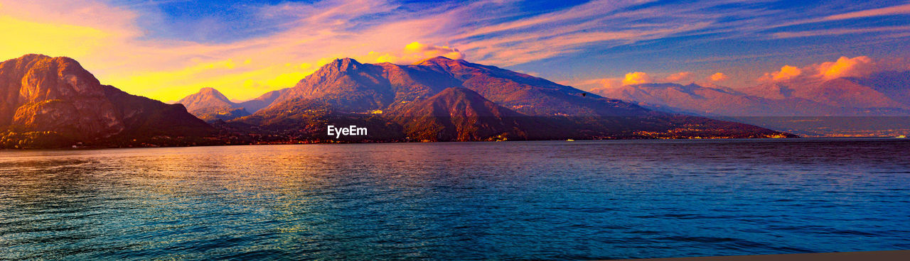 Scenic view of sea and mountains against sky during sunset