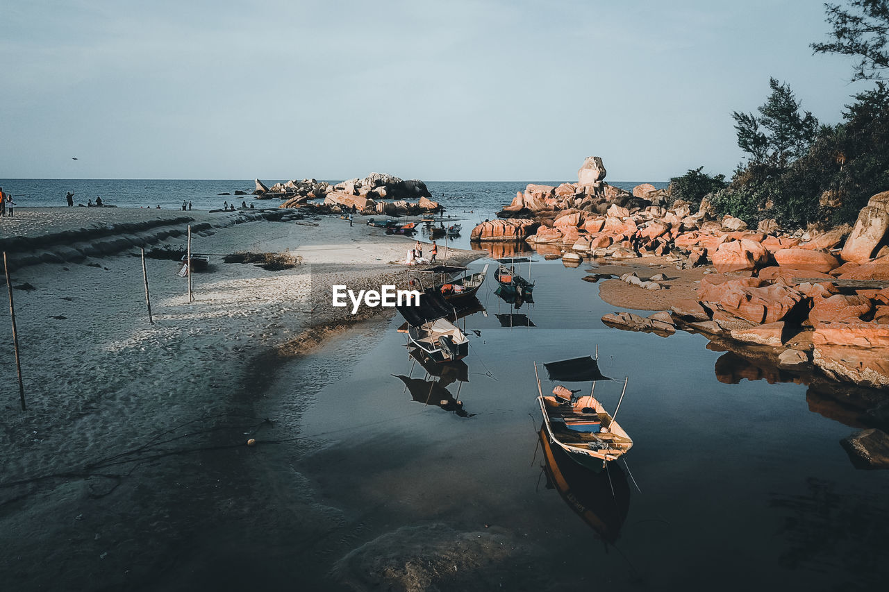 VIEW OF BOATS ON SEA SHORE AGAINST SKY